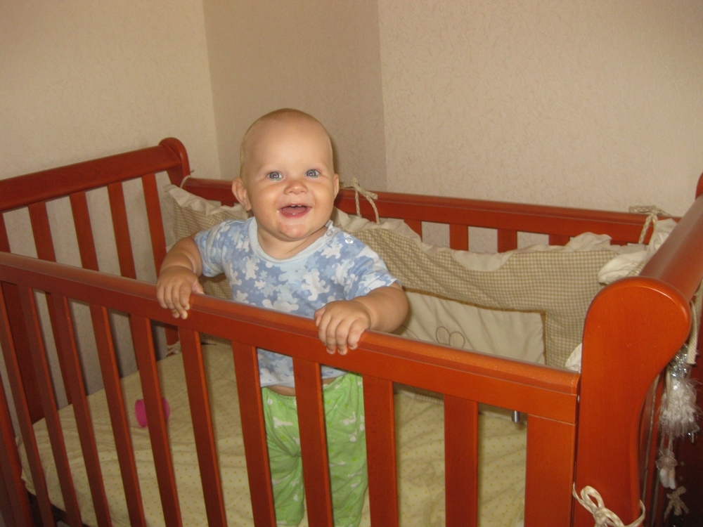 Родившиеся утром. Ребенок стоит в кроватке. Малыш стоящий в кроватки. Младенец стоит в кроватке. Малыш стоит в кроватке.